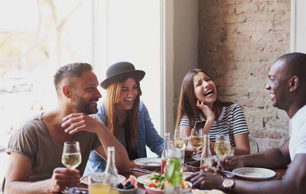 group of coworkers at lunch laughing at perfect resume mistakes