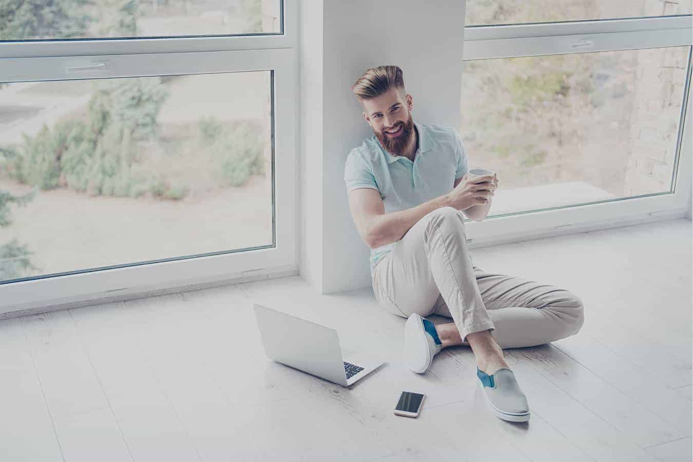 man sitting near window smiling about his perfect resume