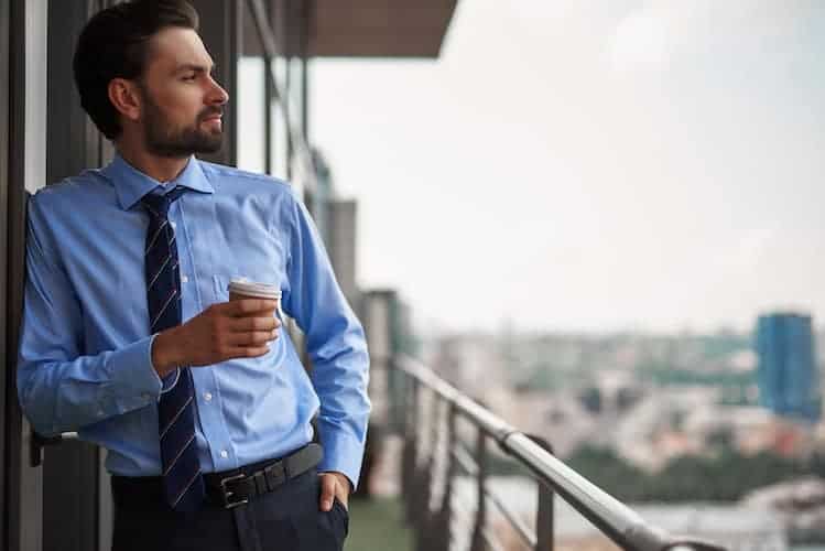 Businessman looking over a downtown balcony.